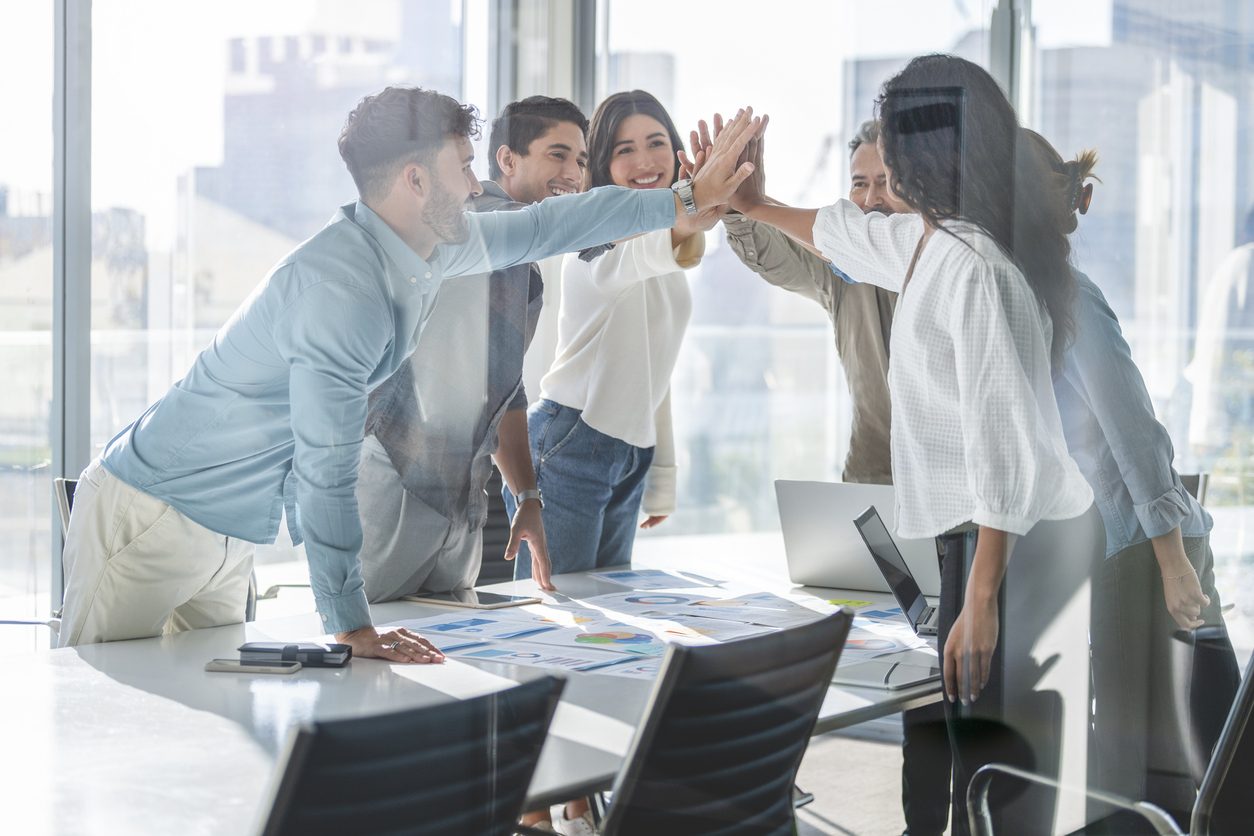 Business team celebrating success with a high five.